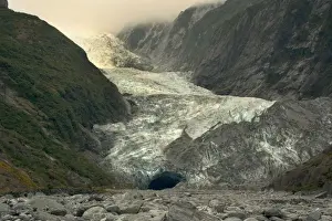Franz Josef Glacier river of ice cutting through glacial valley nestled amidst mountains covered by primeval rainforest Westland National Park, West Coast, South Island, New Zealand