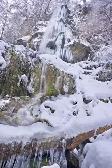 Frozen Waterfall - a waterfall in winter with numerous icicles and snow and ice covered rocks, branches and trees - Swabian Alb - Baden-Wuerttemberg - Germany