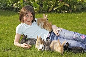 Girl - lying in garden surrounded by rabbits