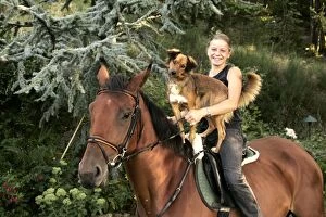 Girl riding horse with dog