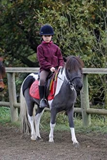 Girl - riding pony in paddock