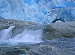 Glacier opening blue glacier ice and glacial river at Nigardsbreen glacier Jostedalsbreen National Park, Norway