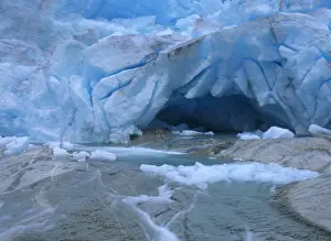 Glacier opening blue glacier ice and glacial river at Nigardsbreen glacier Jostedalsbreen National Park, Norway