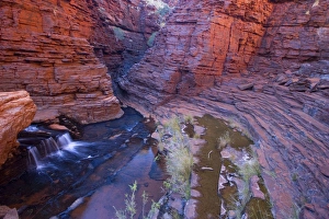 Hancock Gorge - a stream is flowing down Hancock Gorge, surrounded by steep, red and very terraced cliffs