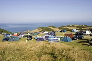 Holiday tents and cars on sloping fields on cliffs