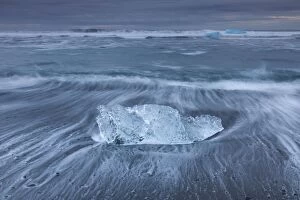 Ice and rushing waves on the beach in winter