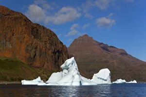 Iceberg drifting in front of coastline Arctic ocean Summer