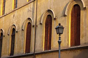 Street Prints: Italy, Tuscany, Lucca. Street lamppost and arched windows with wooden shutters