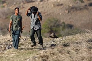 Images Dated 23rd September 2008: Komodo Dragon - following two men along path