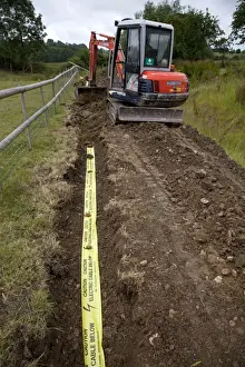 Commercial Prints: Kubota Digger - filling in trench with electric ducting and yellow warning tape - Cotswolds - UK