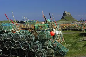 Commerical Prints: Lindisfarne, Holy Island-stacked lobster pots and view of castle, Northumberland UK