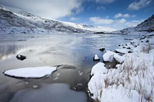 Llyn Ogwen frozen with snow covered hills in winter