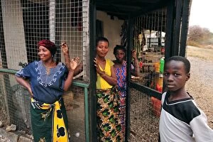 Local Women in front of a house behind cage protection