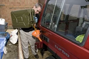Images Dated 4th May 2008: Mechanic pouring biodiesel made from chip fat cooking