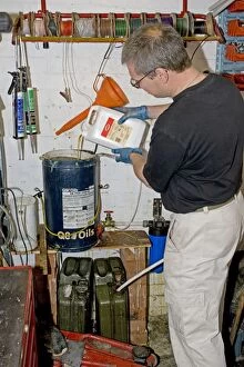 Mechanic in workshop making biodiesel from used