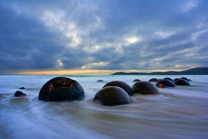 Sunrise Collection: Moeraki Boulders - massive spherical rocks at dawn surrounded by water of incoming tide Coastal