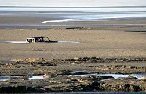 Mudflat Prints: Morecombe Bay quicksands and tide engulf a Four wheel drive vehicle