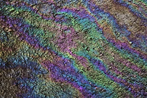 Motor oil creating rainbow pattern on pavement