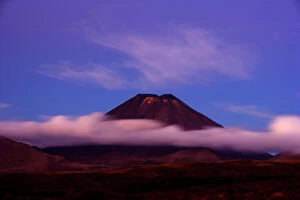 Clouds Gallery: Mount Ngauruhoe - peak of perfectly shaped volcanoe Mt Ngauruhoe sticking out of clouds at dusk