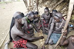 Mursi tribe - boy sitting playing African game