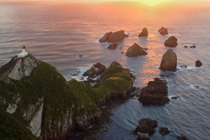 Images Dated 28th January 2008: Nugget Point - sea stacks called nuggets and Nugget Point Lighthouse facing towards rising sun