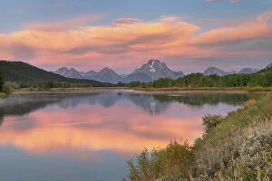Images Dated 8th February 2022: Orange clouds and Mount Moran reflected in still waters of the Snake River at Oxbow Bend at sunrise