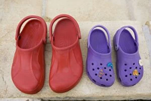 Pair of red adult croc sandals and purple child