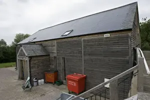 Photovoltaic shingle tile roof - on Brockweir & Hewelsfield Village Shop Forest of Dean UK. Almost the entire roof is photovolatic shingles with just a small strip of ordinary tiles on each side