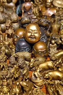 Buddhas Gallery: Pile of brass figures including laughing Buddha head in