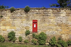 A post box in a wall on a summers day near the cotswold vill