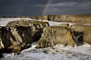 Rainbow over rocky coastline