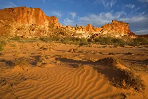 Rainbow Valley - colourful rock formation with bands of different coloured sandstone, from yellow to orange and rusty brown, ablaze in late evening light - Rainbow Valley, Simpson Desert area, Northern Territory, Australia