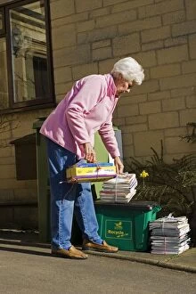 Recycling - pensioner taking neatly tied bundles