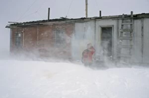 Blizzard Gallery: A researcher outside of a hut of hunters and fishermen