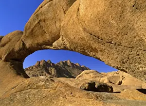 Weathered Prints: Rock arch Pandock mountains seen through a rock arch of red granite Spitzkoppe area