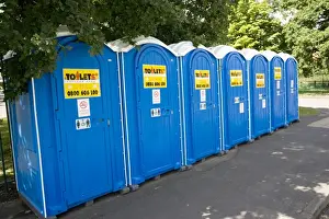 Pavement Prints: Row of blue Portaloos installed on pavement outside Woodmancote Junior School during water crisis when Mythe water