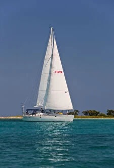Tropic Gallery: A sail boat sailing by Laughing Bird Cay