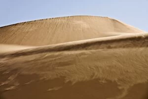 Sand blowing along the slipface of a dune