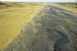 Desertification Prints: Sand dunes in a wind - Karakum desert encroach on a road - near Kumdag - Turkmenistan - former CIS - Spring - April