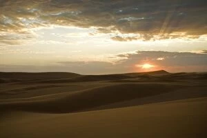 Setting sun in the Namib Dunes - With glowing clouds in the sky