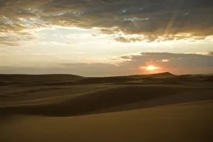 Sun Rays Prints: Setting sun in the Namib Dunes With glowing clouds in the sky Namib Desert