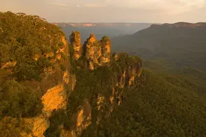 The Three Sisters - famous sandstone formations Three Sisters, seen from Echo Lookout, at sunset. The low sun plunges the scenery in exquisite red light - Blue Mountains National Park, New South Wales, Australia