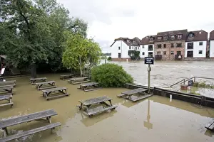 Gloucestershire Prints: Submerged picnic tables in pub alongside River Avon in flood from Mythe Bridge Tewkesbury Gloucestershire UK during
