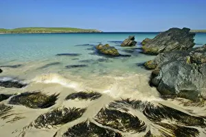 Summer beach approaching wave, blue sea, rocks and white sand at beach of Scousburgh Sands South Mainland, Shetland Isles, Scotland, UK