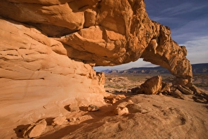 Sunset Arch - beautiful rock arch framing Navajo Mountain in the background. In the evening Sunset Arch - beautiful rock arch framing Navajo Mountain in the background. In the evening
