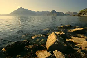 Skye Prints: Sunset at beach near Elgol with boulders in foreground and jagged Cuillin mountains in background Elgol