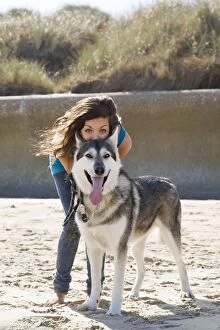 Teenage Girl with Alaskan Malumute (cross) dog on beach