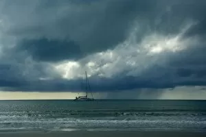 Thunderstorm and boat - tropical thunderstorm is brewing over the ocean at a beach near Cape Tribulation