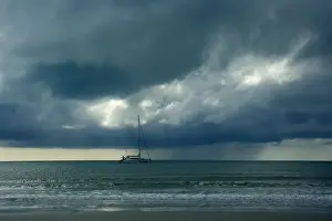 Storms Prints: Thunderstorm and boat - tropical thunderstorm is brewing over the ocean at a beach near Cape Tribulation