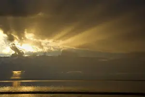 Sun Rays Prints: Thunderstorm over the ocean - dark clouds of a thunderstorm are approaching the beach at Oyster Bay